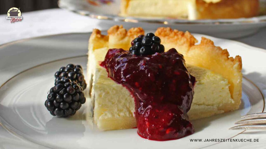 Ein Stück Käsekuchen mit dunkelrotem Brombeermark.