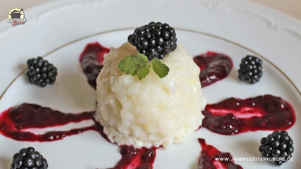 Buttermilchreis mit Brombeermark auf einem weißen Teller