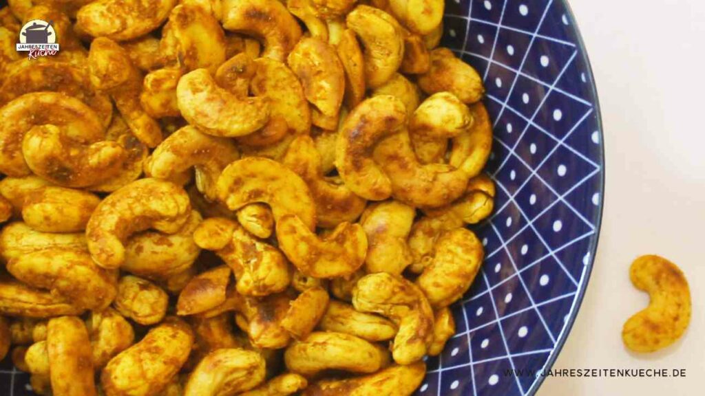 Sonnengelb geröstetet Cashewkerne liegen in einer blauen Schüssel