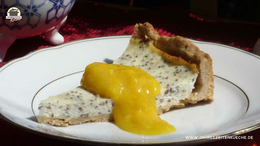 Auf einem Teller liegt ein Stück Käsekuchen mit Chia und Mangomus