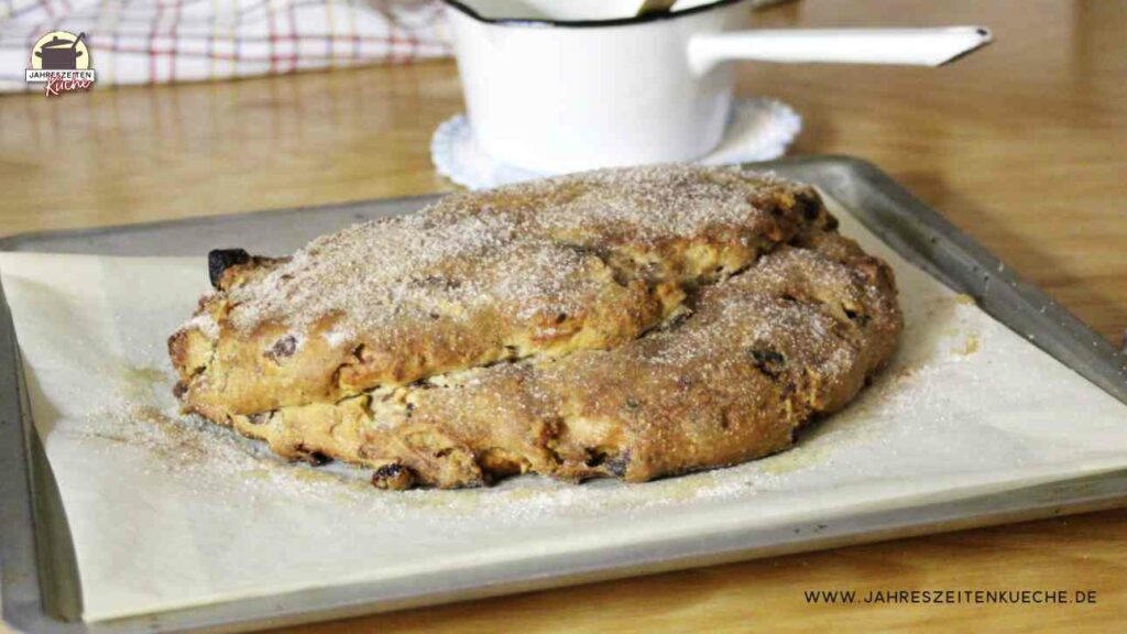 Christstollen mit Butter bepinselt und mit Zimt-Zucker bestreut