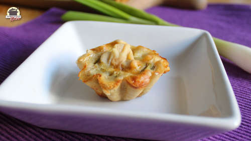 Eine Frühlingszwiebel-Pastete liegt auf einem weißen Teller.