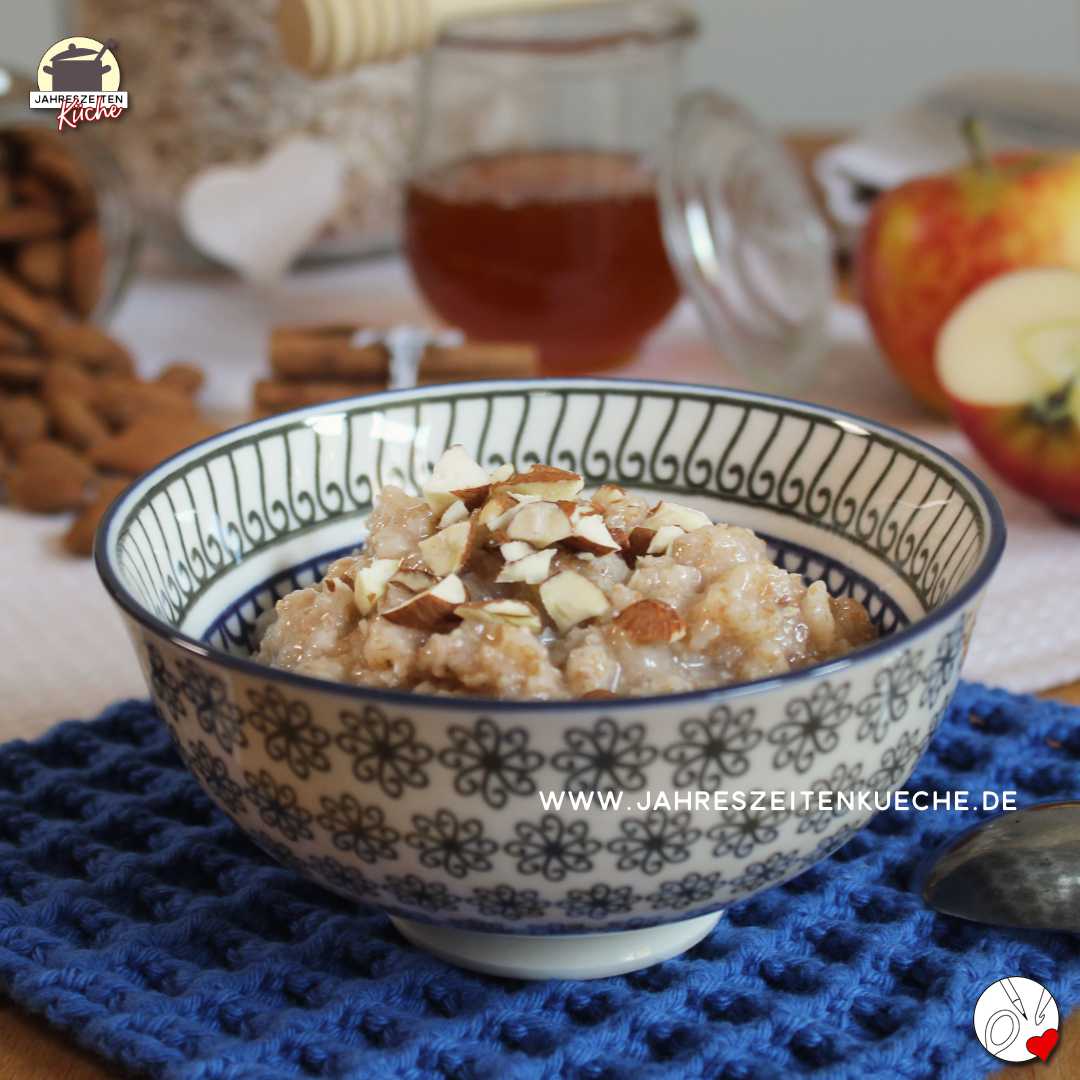 Ein Schälchen mit Habermus. Im Hintergrund steht ein Glas Honig.