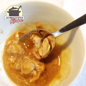 In einer weißen Schüssel sind Hefebrocken, die sich mit dem Honig verbinden