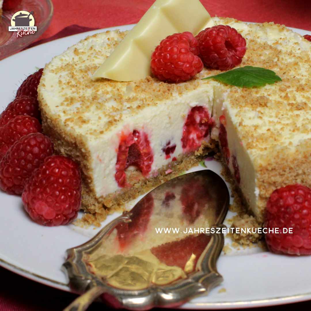Ein angeschnittener Käsekuchen mit Himbeeren spiegelt sich in einem Tortenheber