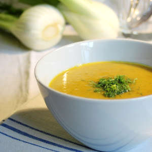 Kartoffelsuppe in einer weißen Schale. Im Hintergrund liegen Fenchelknollen
