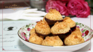 Auf einem weißen Tischtuch steht ein kleiner Teller mit Kokosmakronen