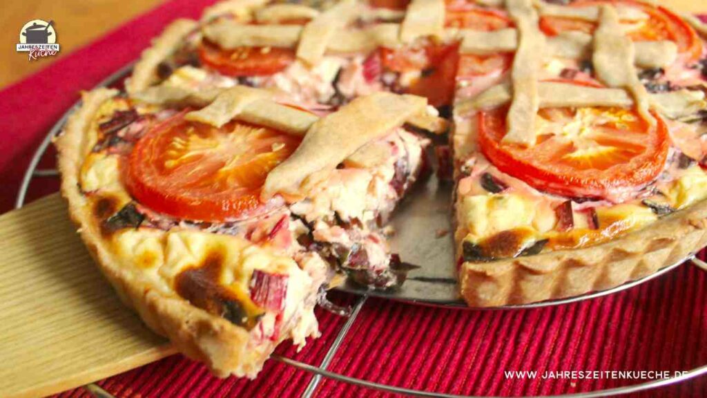 Ein Stück Mangoldquiche mit Fetakäse auf einem Holzspachtel.