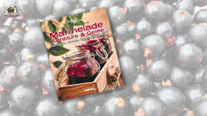 Vor einem Hintergrund mit schwarzen Johannisbeeren liegt das Buch Marmelade Konfitüre & Gelee - einfach, lecker, hausgemacht