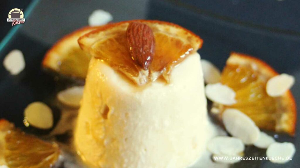 Marzipan-Parfait mit einer Viertel Orangenscheibe und Mandel garniert.