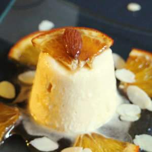 Marzipan-Parfait mit einer Viertel Orangenscheibe und Mandel garniert.