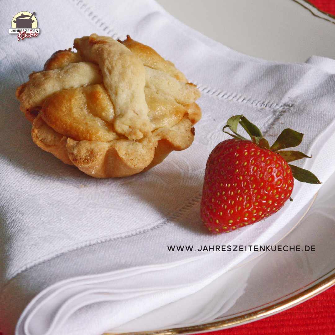 Auf einer weißen Stoffserviette liegen eine Erdbeer-Masarine und eine Erdbeere