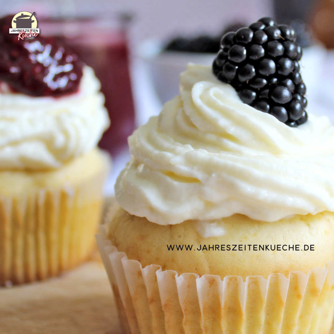 Ein Vanillepudding-Muffins mit Frosting und Brombeere garniert.
