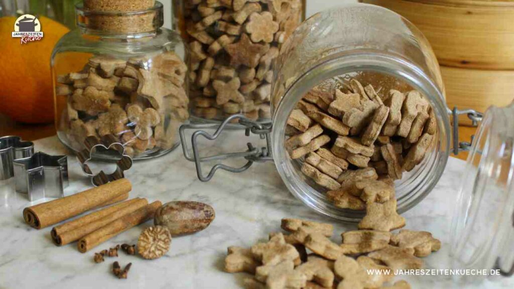 Mehrere Gläser sind mit Energiekeksen gefüllt. Ein Glas liegt geöffnet auf einer Marmorplatte.