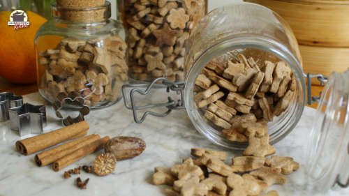 Mehrere Gläser sind mit Energiekeksen gefüllt. Ein Glas liegt geöffnet auf einer Marmorplatte.