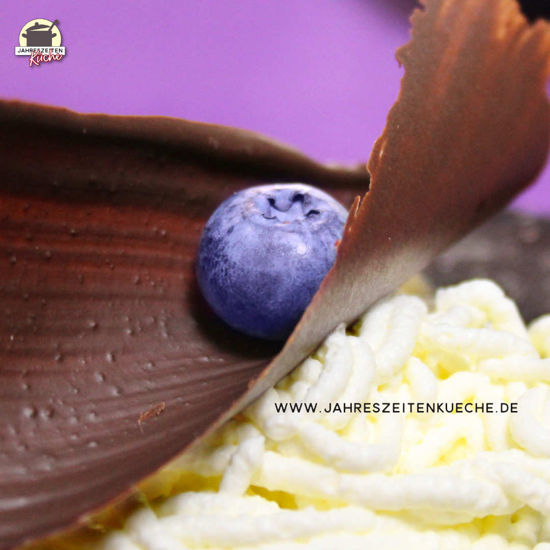 In der Mitte einer bizarren Schokoladenwelle liegt eine Heidelbeere.