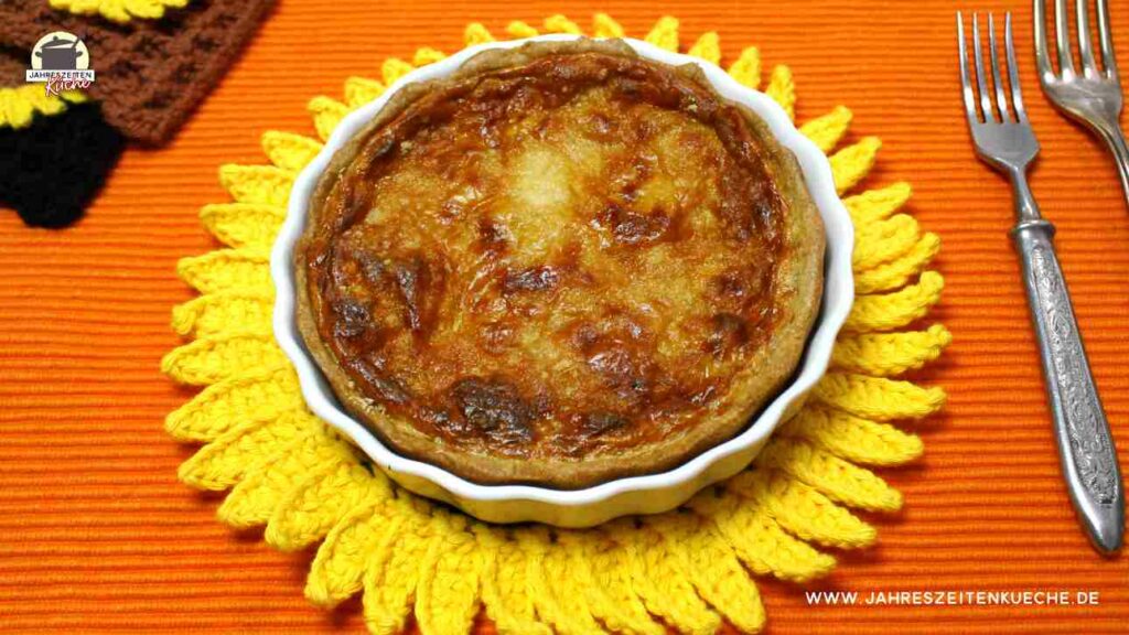 Eine kleine Pastinaken-Quiche steht auf einem Sonnenblumen-Untersetzer.