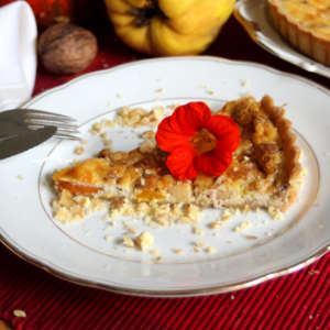 Auf einem weißem Teller liegt ein Stück Kürbis-Quitten-Quiche