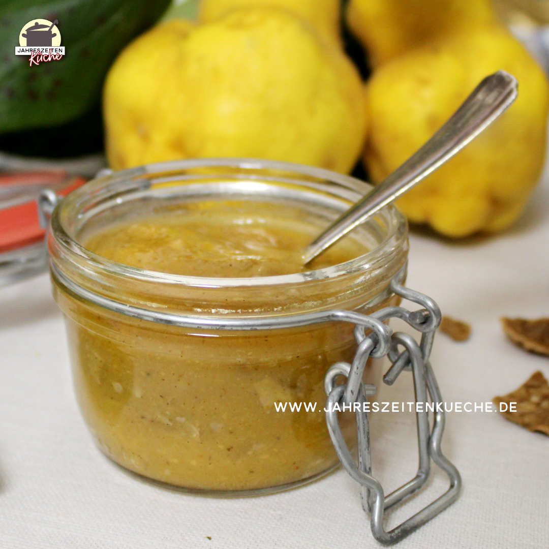 Vor zwei Quitten steht ein Glas Quittenmarmelade.