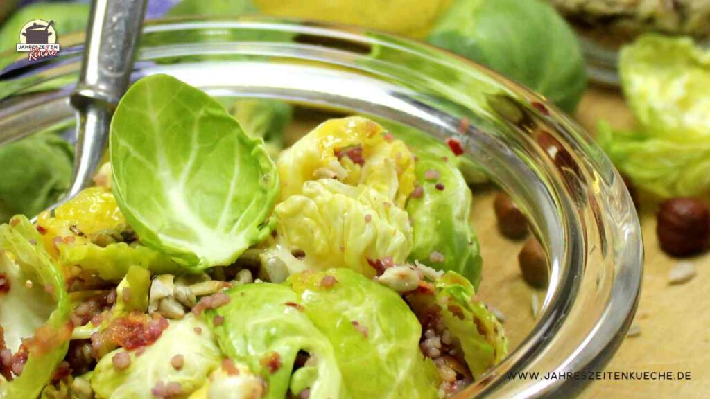 Eine Glasschüssel ist mit Rosenkohlsalat gefüllt.