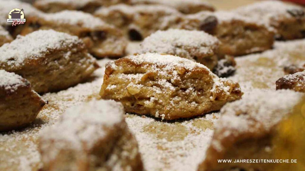 Auf einem Backblech liegt Stollenkonfekt, das mit Puderzucker bestreut ist.