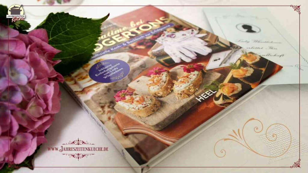 Auf einem gedeckten Tisch liegt das inoffiziellen Koch- und Backbuch Teatime bei Bridgertons von Tom Grimm