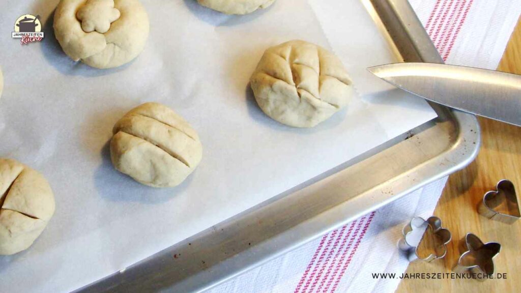 Verzierte Teiglinge liegen auf einem Backblech