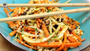 Essstäbchen und Wok-Gemüse in einer türkisfarbenen Schüssel