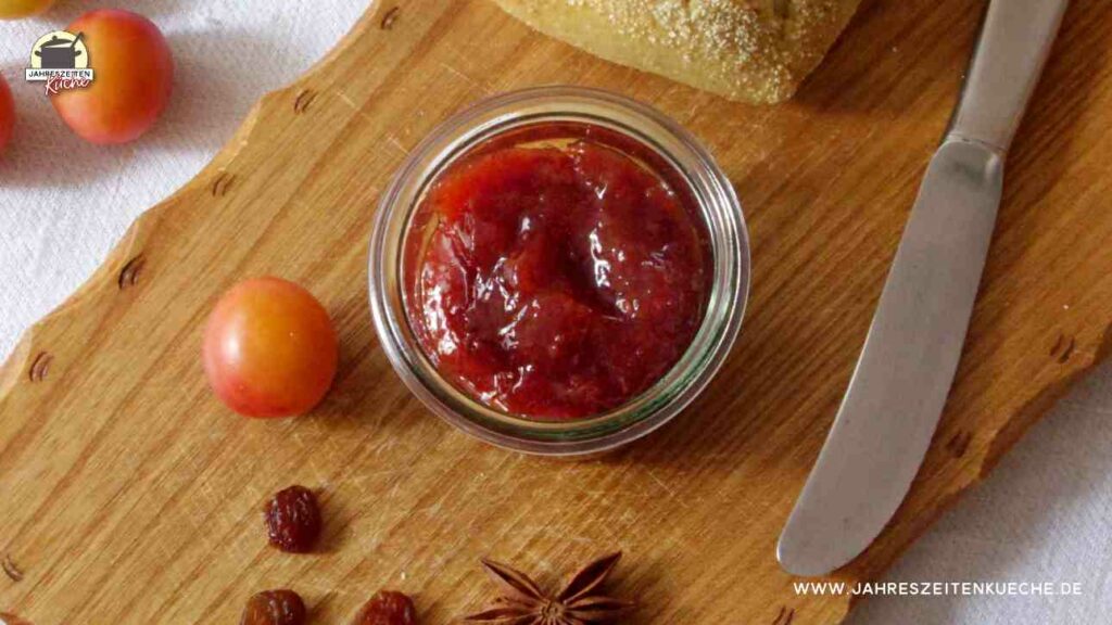 Wildpflaumen-Rosinen-Marmelade mit Sternanis auf einem Holzbrett
