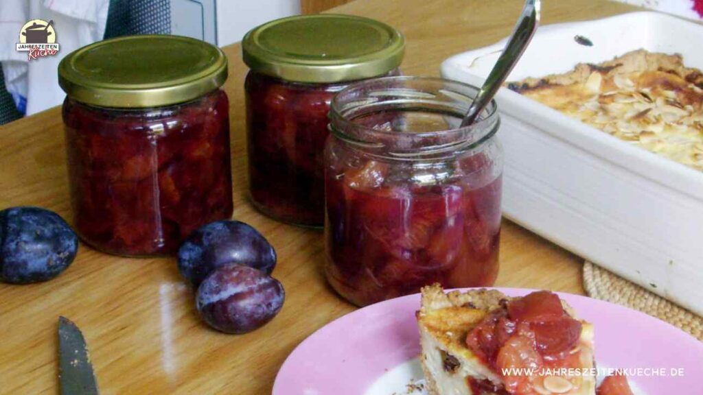 3 Gläser Zwetschgenkompott stehen auf dem Tisch. Davor liegen 3 Zwetschgen