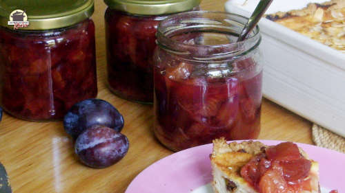 3 Gläser Zwetschgenkompott stehen auf dem Tisch. Davor liegen 3 Zwetschgen