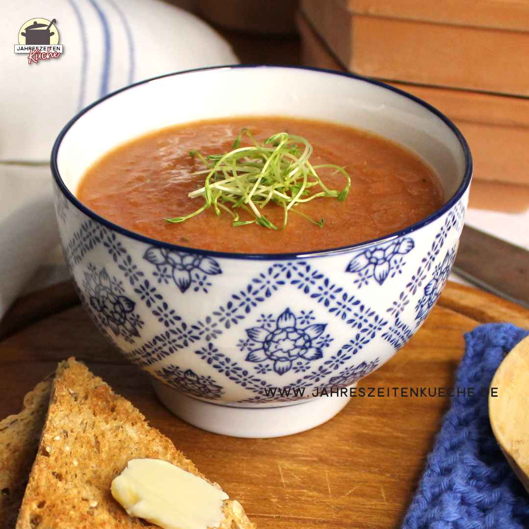 Eine blau-weiße Schale enthält Pastinaken-Suppe mit Zimt. Daneben liegen Toatscheiben