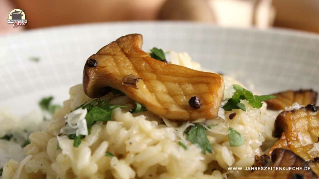 Ein gebratener Kräuterseiling liegt auf dem fertigen Risotto