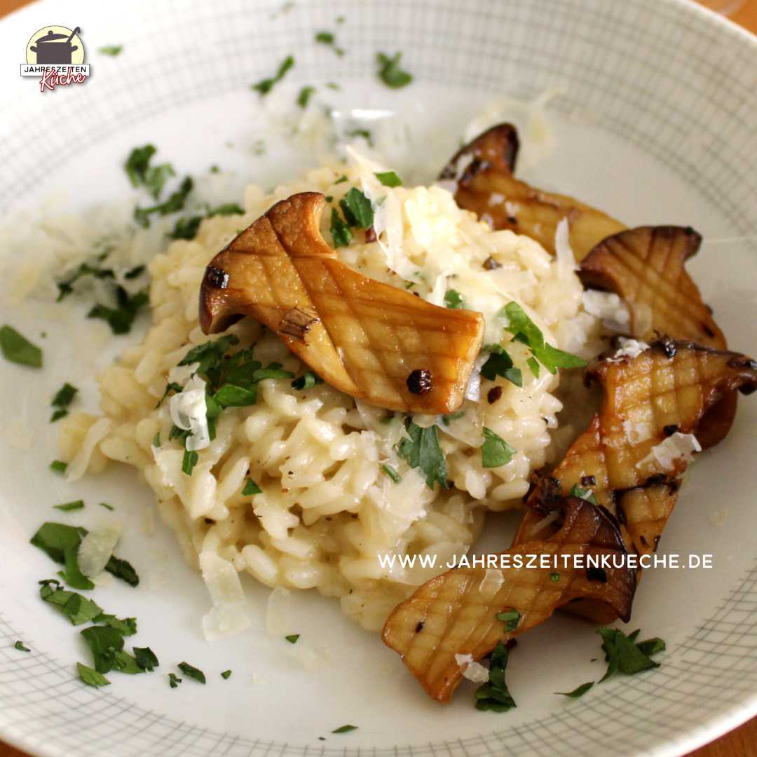 Risotto mit gebratenen Kräuterseitlingen ist auf einem Teller angerichtet.