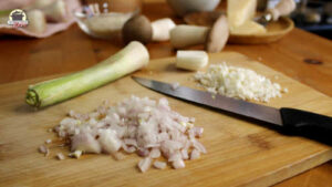Fein geschnittene Zwiebeln und Knoblauch auf einem Holzbrett