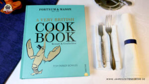 Neben dem Buch von Tom Parker Bowles "A Very Britisch Cookbook liegen zwei Gabeln und eine Stoffserviette