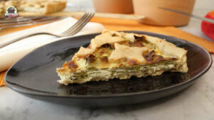 Ein Stück Mairübchen-Quiche liegt auf einem ovalen Keramikteller