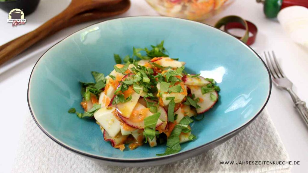 Eine Portion Mairübchen-Salat mit Grün bestreut in einer türkisfarbenen Bowl.