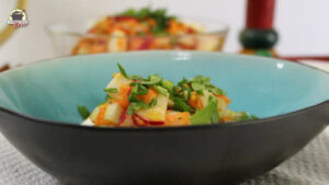In einer türkisfarbenen Bowl ist eine Portion Mairübchen-Salat mit Grün bestreut