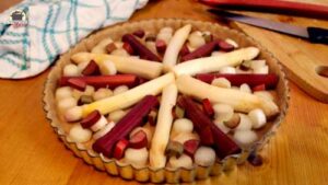 Eine Quicheform ist mit Spargel- und Rhabarberstücken belegt