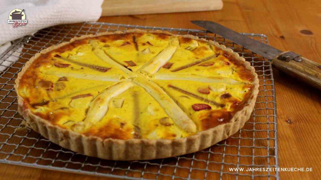 Eine Spargel-Rhabarber-Quiche liegt auf einem Küchengitter