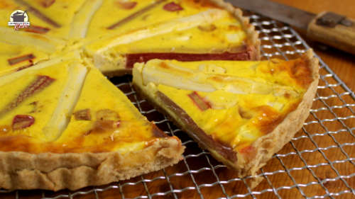 Eine angeschnittene Spargel-Rhabarber-Quiche liegt auf einem Küchengitter