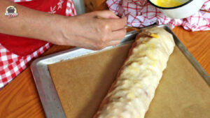Strudel wird mit flüssiger Butter bestrichen