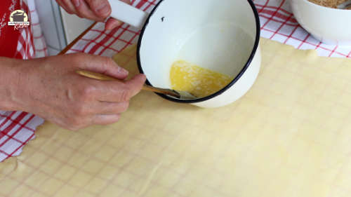 Strudelteig wird mit flüssiger Butter bestrichen