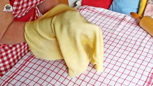 Strudelteig wird mit den Händen ausgezogen