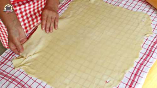 Ausgerollter Strudelteig wird glatt auf einem Leinentuch ausgelegt