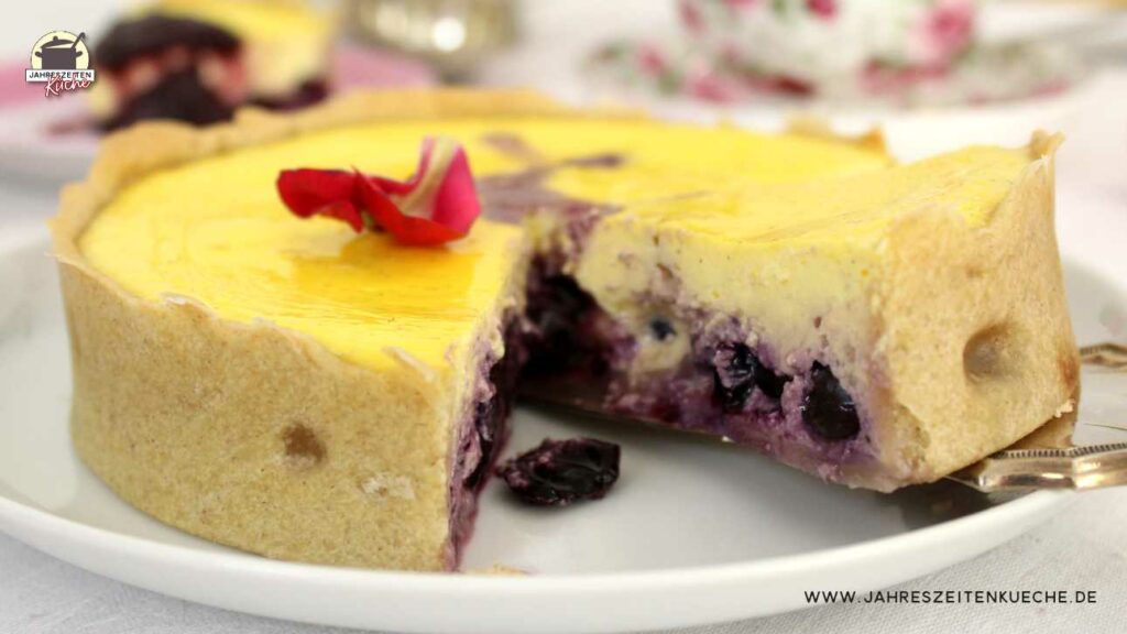 Ein Stück Käsekuchen mit Heidelbeeren wird mit einem Tortenheber vom Kuchenteller gehoben