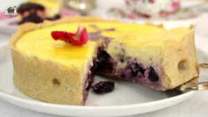 Ein Stück Käsekuchen mit Heidelbeeren wird mit einem Tortenheber vom Kuchenteller gehoben