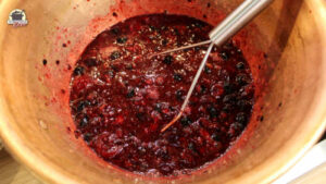 Ein Kupfertopf mit Saft von den zerstampften Beeren und Kirschen.