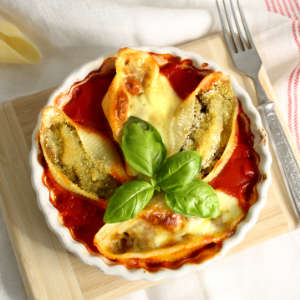 In einer kleinen Auflaufformen sind vier überbackene Conchiglioni in Tomatensauce